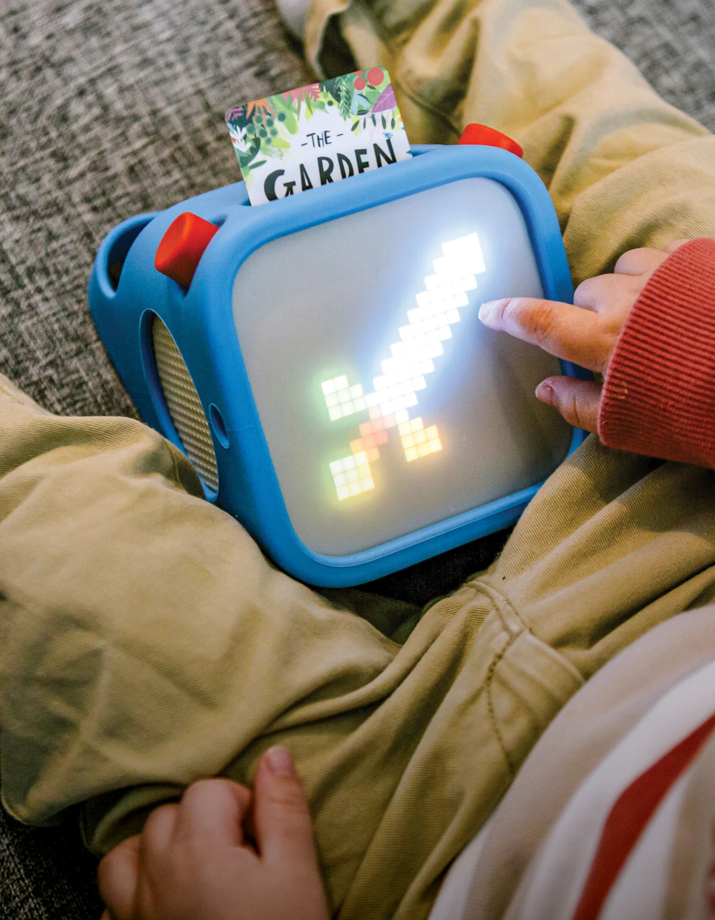 Photograph of a child with a yoto player and a card