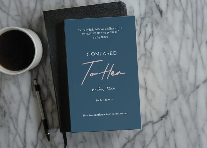 Photograph of Compared to Her on a marble tabletop with a bible and a coffee