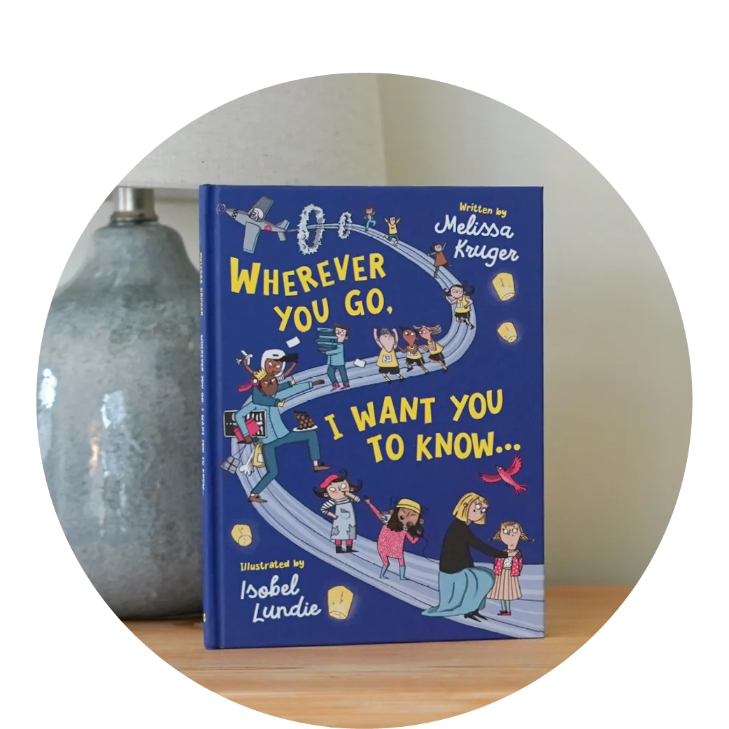 photograph of Wherever You Go, I Want You to Know propped up on a wooden table near a ceramic lamp