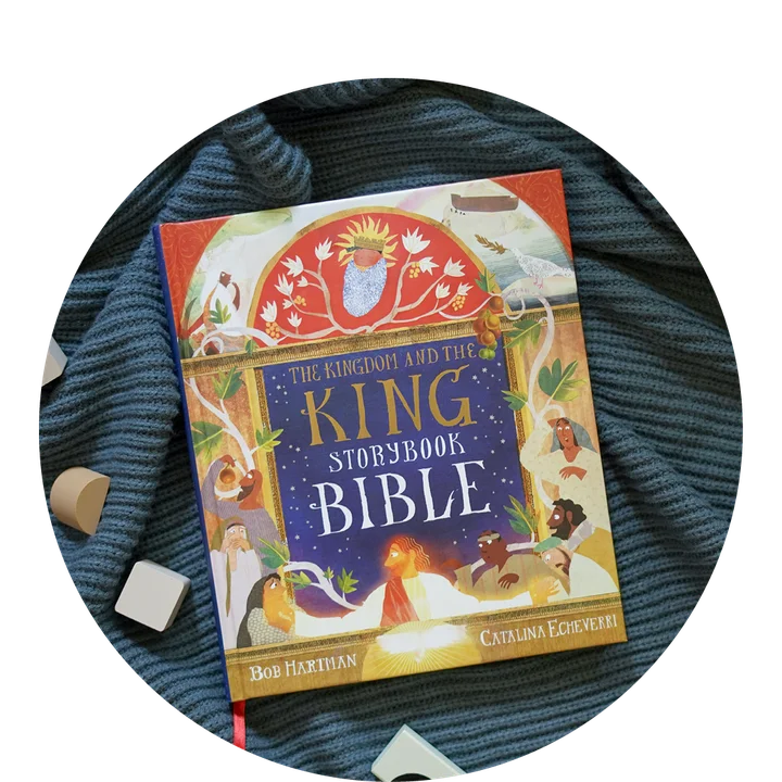Photograph of The Kingdom and the King Storybook Bible on a ribbed knit blanket with some wooden blocks spread around it